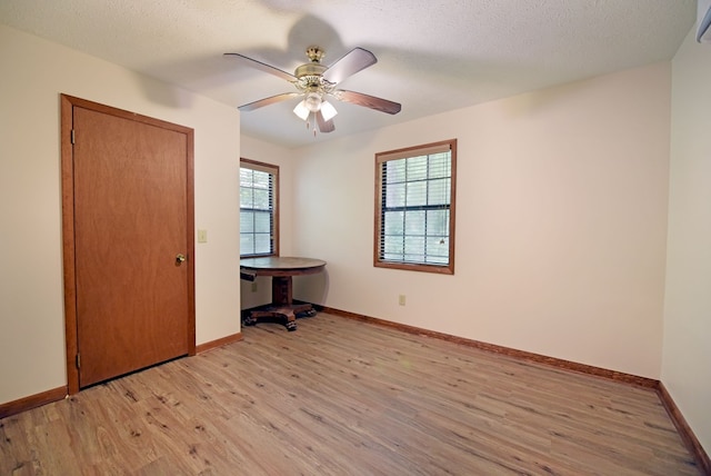 unfurnished bedroom featuring a textured ceiling, light wood-type flooring, and ceiling fan