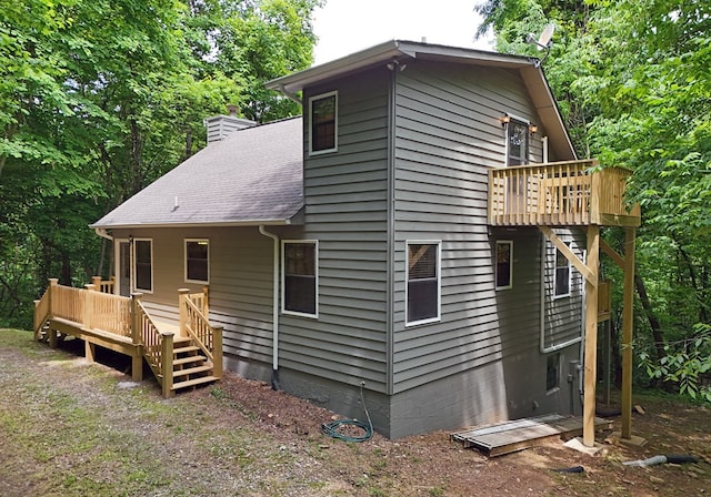 rear view of house featuring a wooden deck