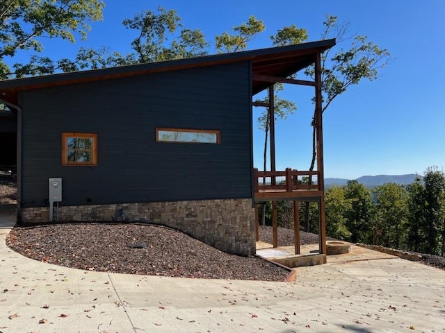 view of side of home featuring a mountain view and a patio area