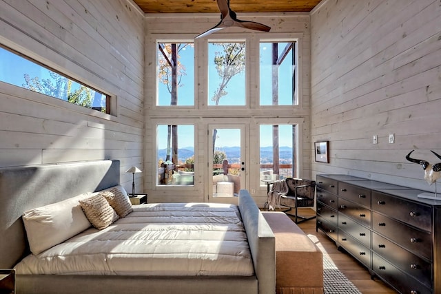 bedroom featuring wooden walls and multiple windows