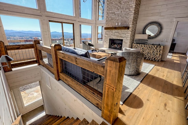 living room with hardwood / wood-style floors, a healthy amount of sunlight, a mountain view, and wooden walls