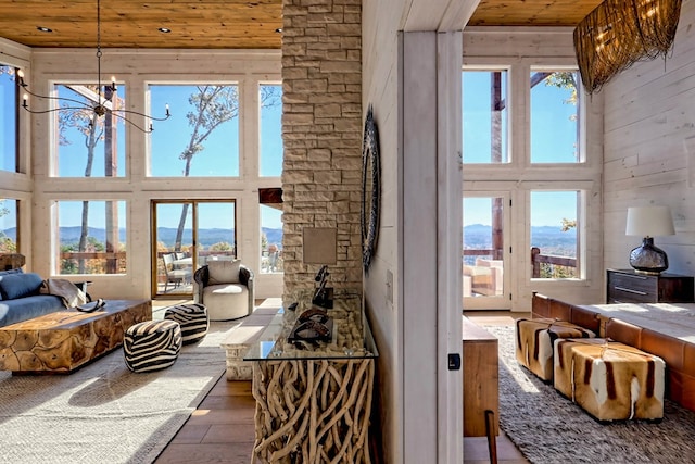 living area with a chandelier, a towering ceiling, and wood ceiling