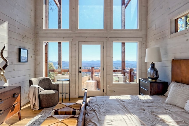 bedroom featuring a mountain view, multiple windows, and a high ceiling
