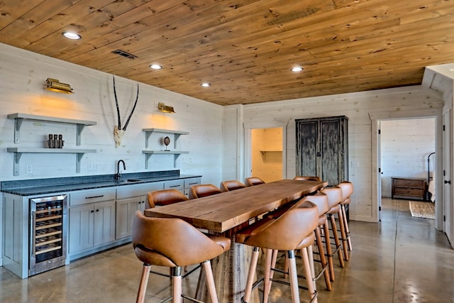 dining room featuring recessed lighting, finished concrete floors, wooden ceiling, and wine cooler