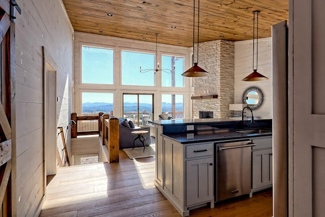kitchen featuring a mountain view, a sink, dark countertops, wood ceiling, and gray cabinetry