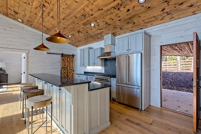 kitchen with dark countertops, high end appliances, light wood-style floors, lofted ceiling, and wood ceiling