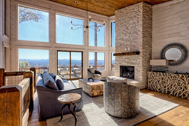 living room with a wealth of natural light, hardwood / wood-style floors, a towering ceiling, and wood ceiling