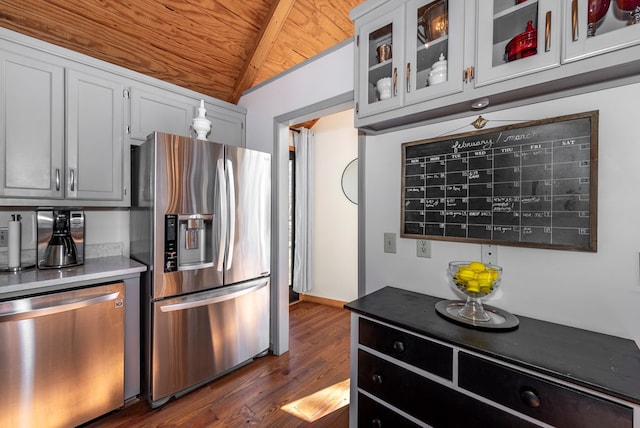 kitchen featuring lofted ceiling, stainless steel appliances, wood ceiling, dark wood finished floors, and glass insert cabinets