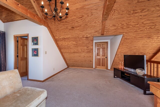 sitting room with vaulted ceiling with beams, carpet flooring, a chandelier, and baseboards