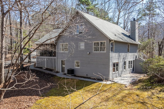 back of property with a chimney, central AC, and a patio