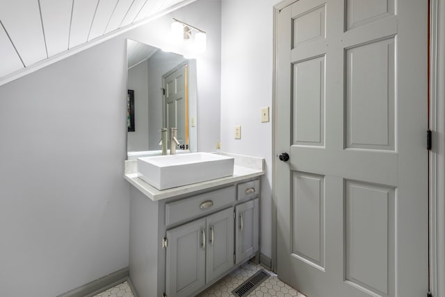 bathroom featuring visible vents, vanity, and baseboards