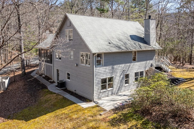 back of property with central air condition unit, a patio area, a chimney, and stairway