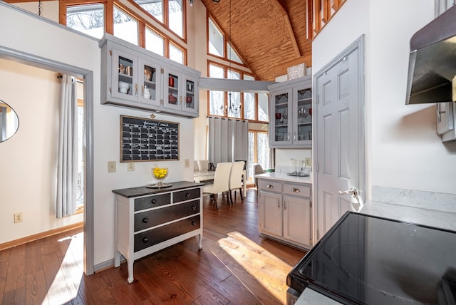 kitchen featuring electric stove, dark wood-style floors, wood ceiling, glass insert cabinets, and high vaulted ceiling