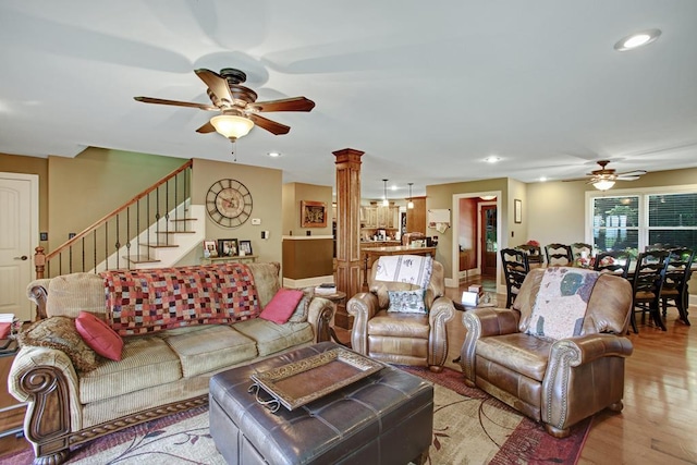 living room featuring ornate columns, ceiling fan, and light hardwood / wood-style floors