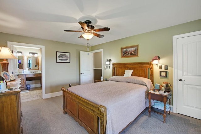 bedroom with light carpet, ensuite bathroom, and ceiling fan