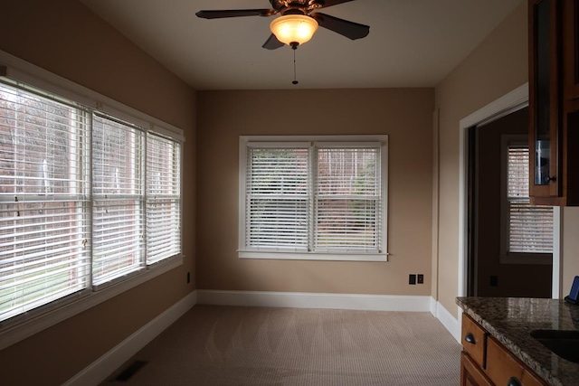 dining room with light colored carpet, ceiling fan, and a healthy amount of sunlight