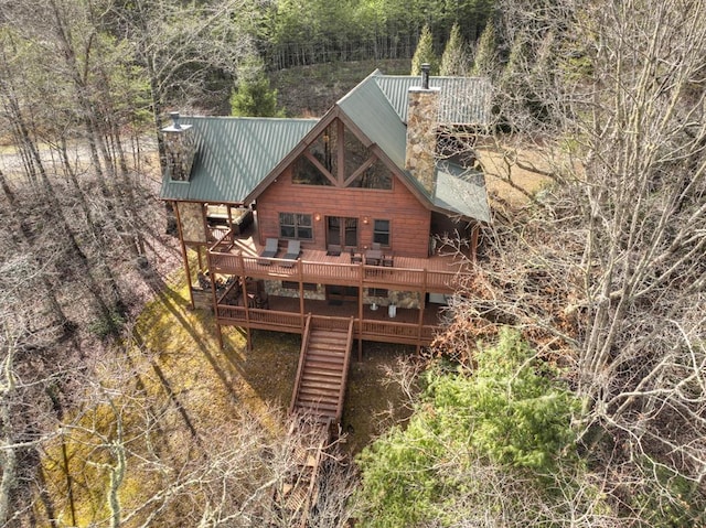 back of house with stairs, metal roof, a deck, and a chimney