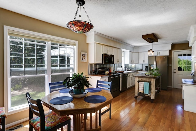 dining space with dark hardwood / wood-style floors, a wealth of natural light, and a textured ceiling