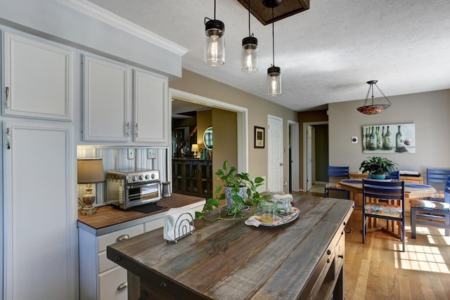 dining area with light hardwood / wood-style floors and a textured ceiling