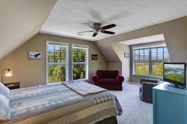 carpeted bedroom with lofted ceiling, ceiling fan, and a textured ceiling