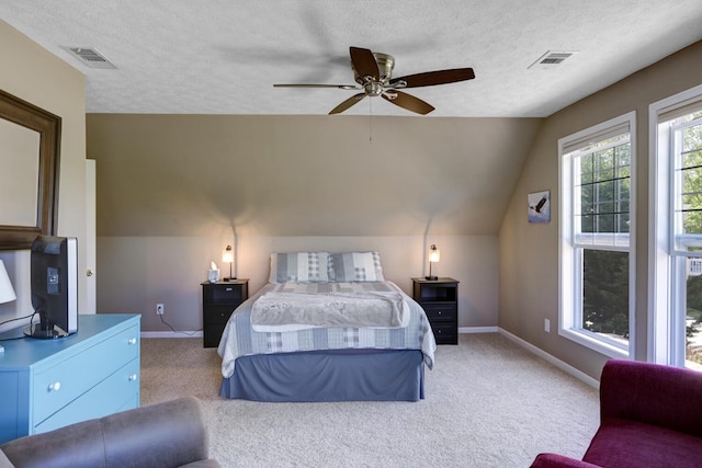 bedroom featuring ceiling fan, carpet floors, lofted ceiling, and a textured ceiling