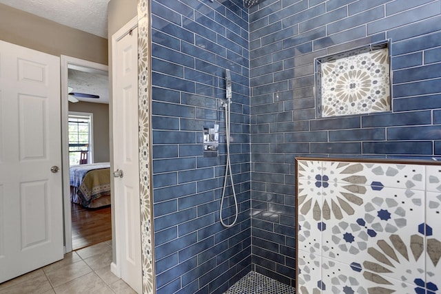 bathroom featuring hardwood / wood-style flooring, a tile shower, ceiling fan, and a textured ceiling