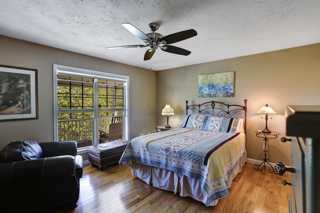 bedroom with a textured ceiling, ceiling fan, and light hardwood / wood-style flooring