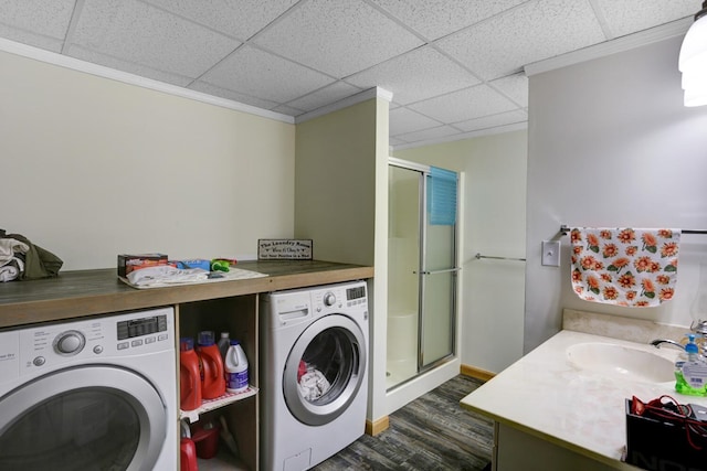 clothes washing area featuring separate washer and dryer, dark hardwood / wood-style floors, sink, and crown molding