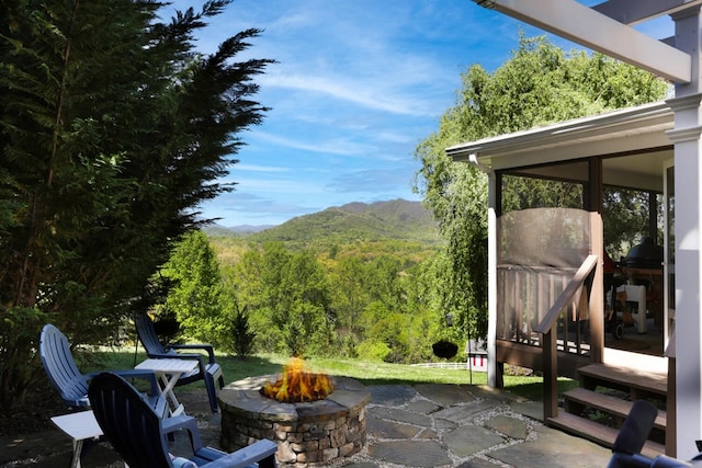 view of patio / terrace featuring an outdoor fire pit and a mountain view