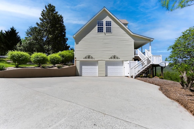 view of side of home featuring a garage and covered porch