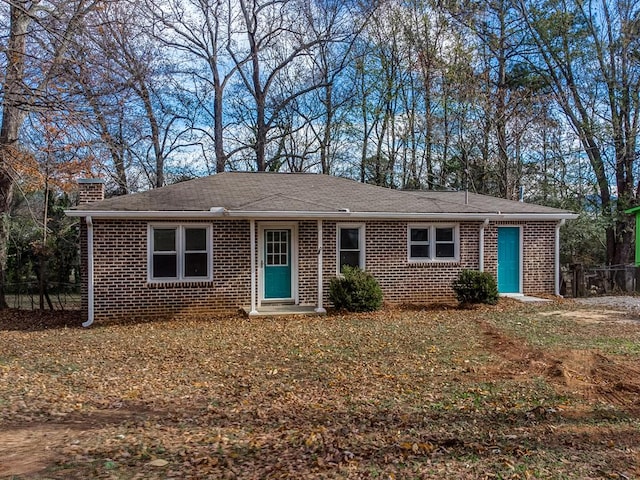 single story home with brick siding and a chimney