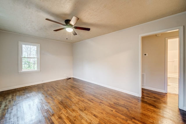 spare room featuring crown molding, a ceiling fan, a textured ceiling, wood finished floors, and baseboards