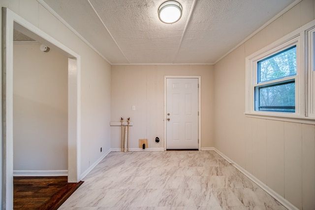 laundry room with laundry area, crown molding, baseboards, and a textured ceiling