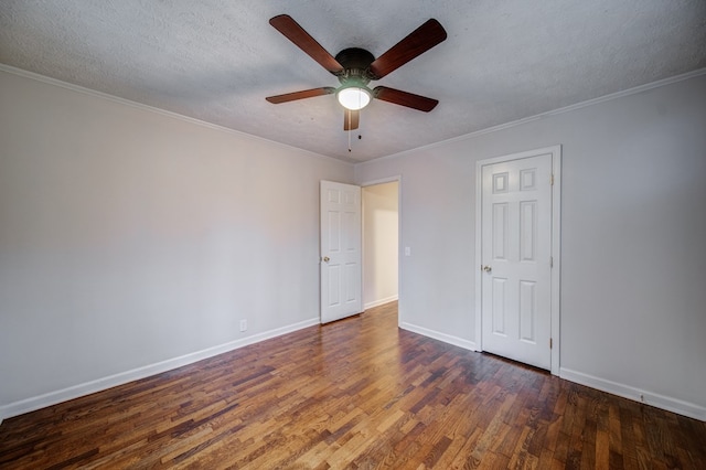 unfurnished room featuring a textured ceiling, baseboards, wood finished floors, and crown molding