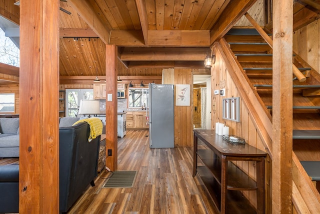 interior space with wood ceiling, wood walls, dark wood-type flooring, and beam ceiling