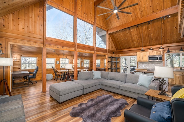 living room featuring beam ceiling, high vaulted ceiling, wooden ceiling, and light wood-type flooring