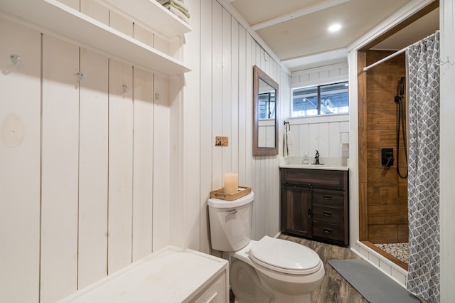 bathroom featuring curtained shower, wooden walls, vanity, and toilet