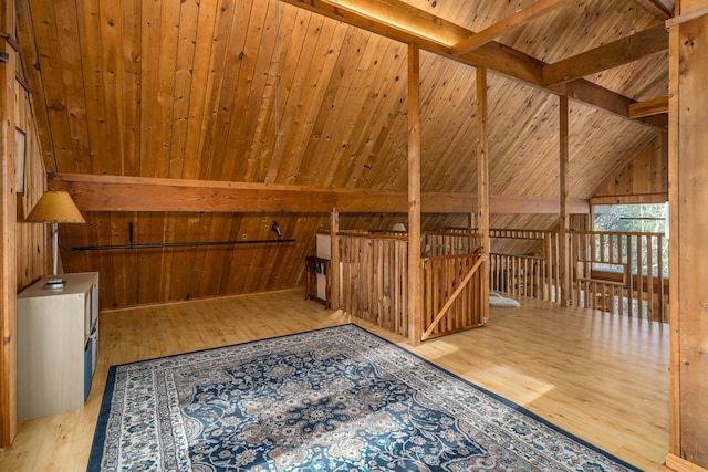 bonus room featuring wooden ceiling, light hardwood / wood-style flooring, lofted ceiling with beams, and wood walls