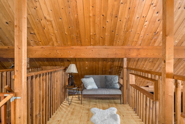 living area with beam ceiling, light hardwood / wood-style flooring, and wooden ceiling