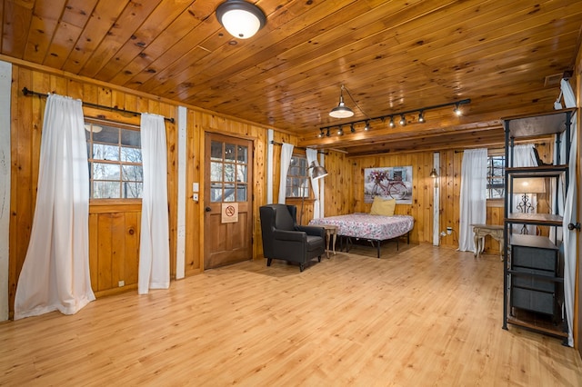 sitting room featuring wood walls, light hardwood / wood-style floors, rail lighting, and wooden ceiling