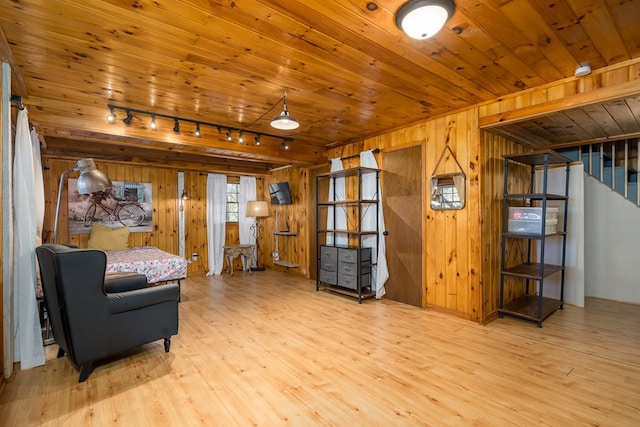 living area with wooden ceiling, wood walls, light wood-type flooring, and track lighting