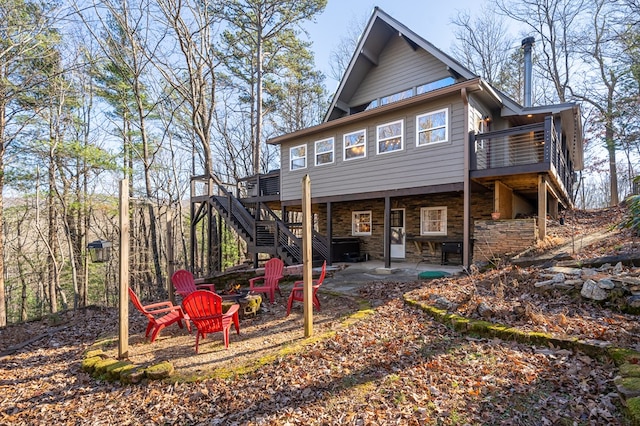 rear view of property with a fire pit, a patio area, and a wooden deck