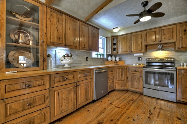 kitchen featuring brown cabinets, light wood-style floors, stainless steel appliances, and light countertops