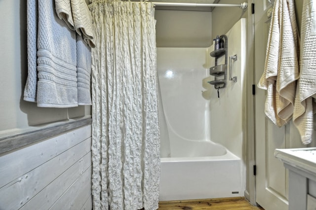 bathroom with shower / bath combination with curtain and wood finished floors