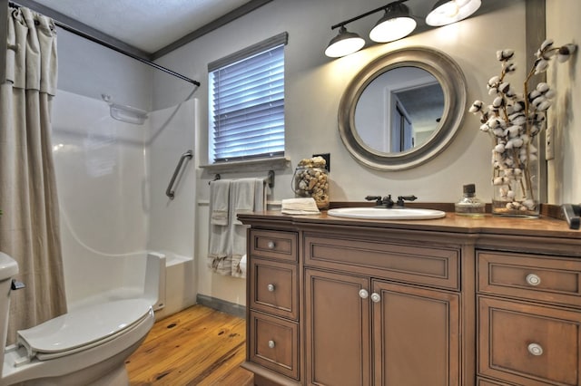 bathroom featuring toilet, curtained shower, wood finished floors, and vanity