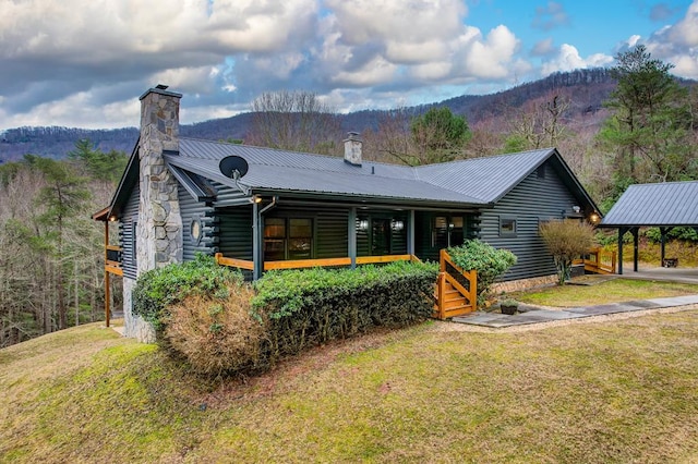 view of front facade with a carport, a mountain view, and a front yard