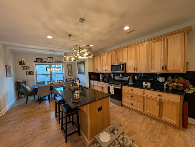 181 Charles Ln, Morganton, GA 30560 - kitchen featuring appliances with stainless steel finishes, a chandelier, backsplash, a breakfast bar area, and a sink