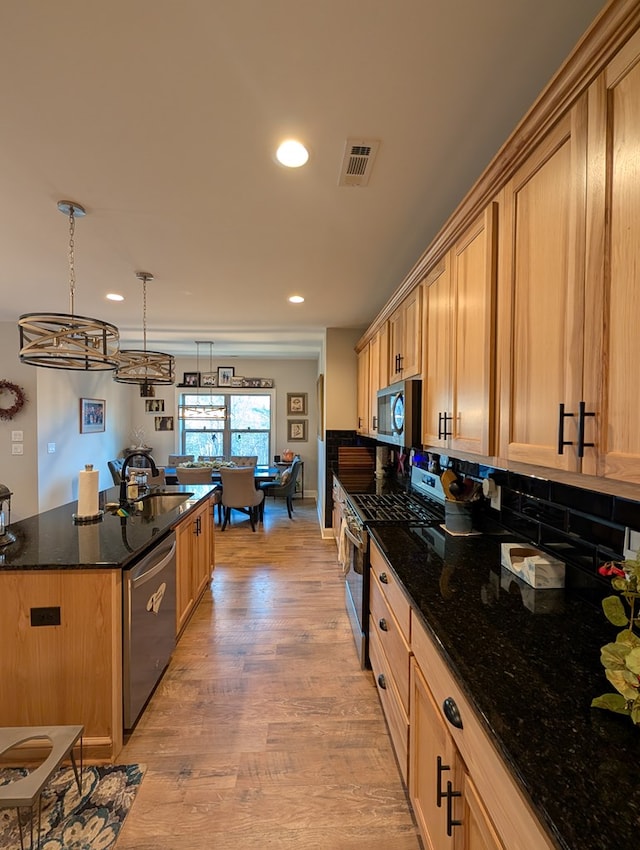181 Charles Ln, Morganton, GA 30560 - kitchen featuring stainless steel appliances, a sink, light wood-style floors, a center island, and dark stone countertops