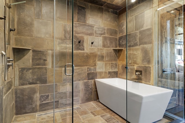 bathroom with shower with separate bathtub and tile walls