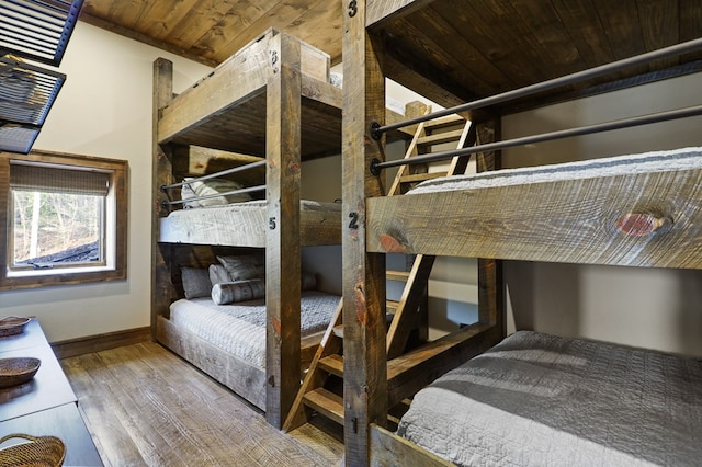 bedroom featuring hardwood / wood-style flooring, vaulted ceiling, and wooden ceiling